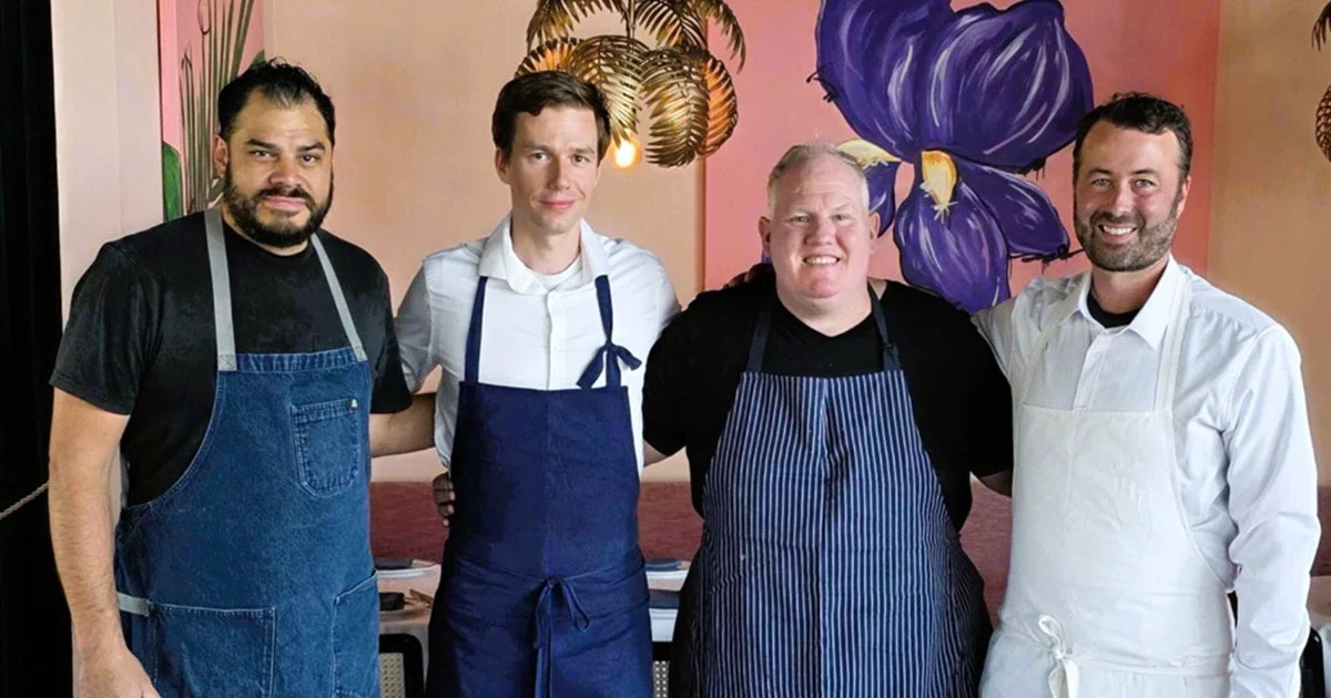 Four chefs in aprons standing together in a restaurant